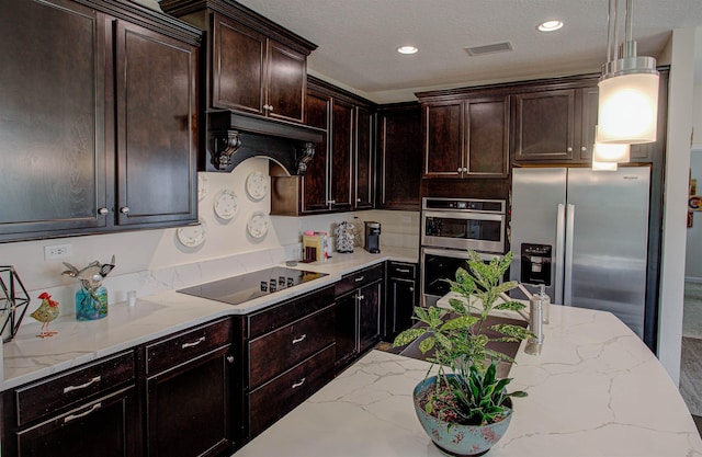 kitchen with light stone countertops, dark brown cabinets, a textured ceiling, stainless steel appliances, and decorative light fixtures