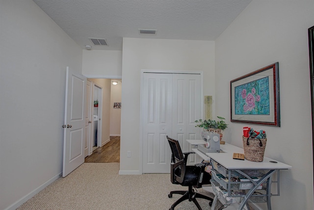 office with carpet floors and a textured ceiling