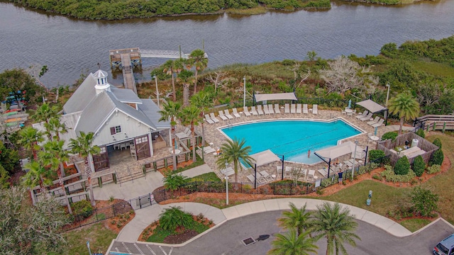 view of swimming pool with a patio area and a water view