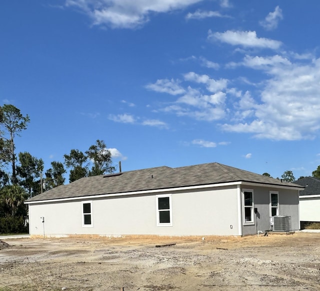 back of house with central AC unit