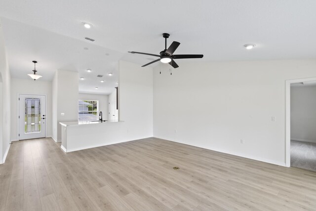 10 Reine Pl, Palm Coast, FL 32164 - unfurnished living room featuring lofted ceiling, ceiling fan, light wood-style floors, baseboards, and a sink