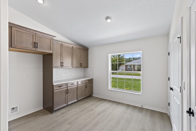 10 Reine Pl, Palm Coast, FL 32164 - kitchen with light wood-style floors, lofted ceiling, light countertops, backsplash, and baseboards