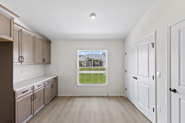 10 Reine Pl, Palm Coast, FL 32164 - kitchen with light wood-style flooring, light countertops, decorative backsplash, and baseboards