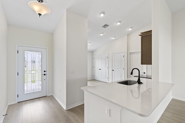 10 Reine Pl, Palm Coast, FL 32164 - kitchen with a sink, light wood-style flooring, baseboards, light countertops, and vaulted ceiling