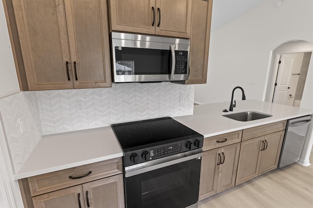 10 Reine Pl, Palm Coast, FL 32164 - kitchen with stainless steel appliances, a sink, arched walkways, light countertops, and tasteful backsplash