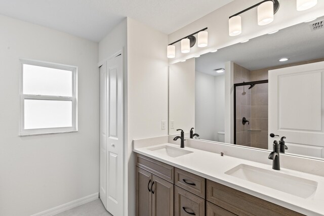 10 Reine Pl, Palm Coast, FL 32164 - full bath with a tile shower, toilet, double vanity, and baseboards