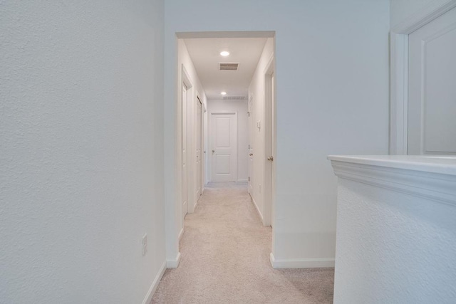 hallway with light colored carpet