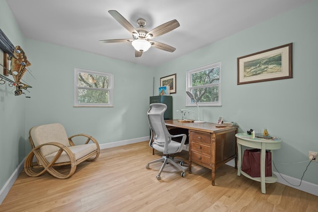 office area with light wood finished floors, ceiling fan, and baseboards