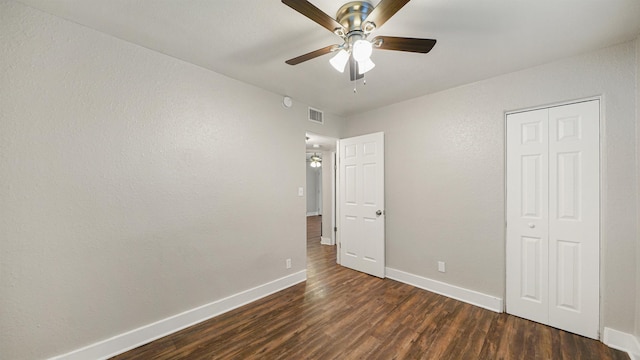 unfurnished bedroom featuring ceiling fan, a closet, and dark hardwood / wood-style floors