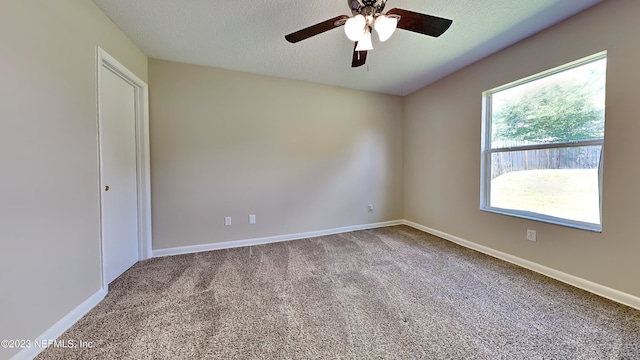 unfurnished room with carpet flooring, ceiling fan, and a textured ceiling