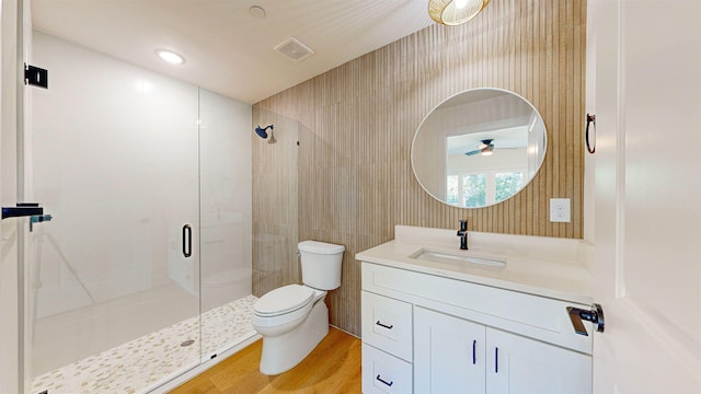 bathroom featuring vanity, hardwood / wood-style floors, a shower with shower door, and toilet