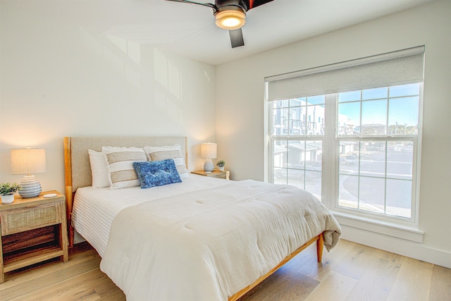 bedroom featuring multiple windows, ceiling fan, and light hardwood / wood-style floors