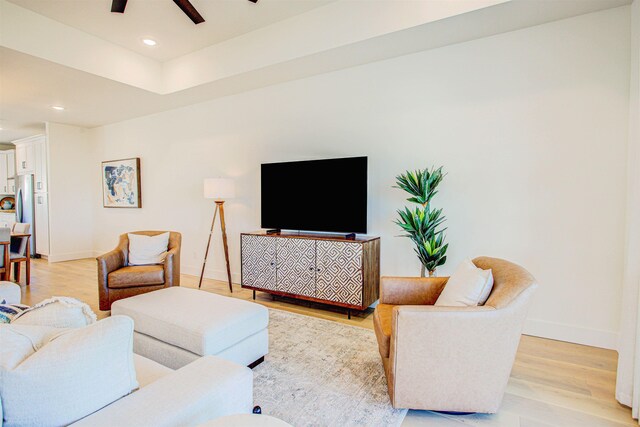 living room with ceiling fan and light hardwood / wood-style flooring