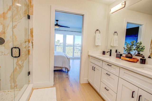 bathroom featuring vanity, hardwood / wood-style floors, an enclosed shower, and ceiling fan