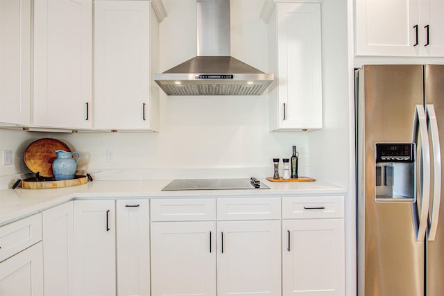 kitchen featuring extractor fan, stainless steel fridge with ice dispenser, black electric stovetop, light stone countertops, and white cabinets