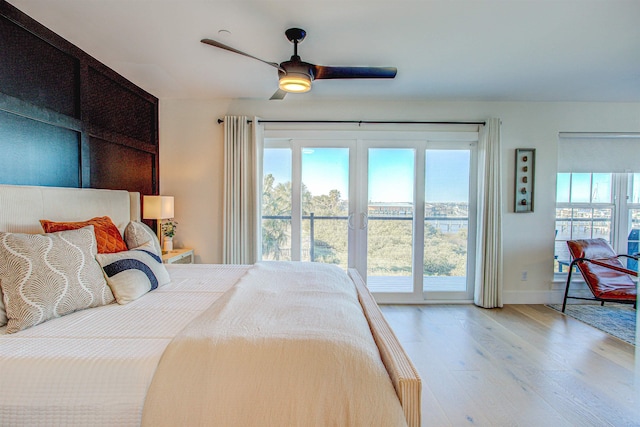 bedroom with multiple windows, access to outside, ceiling fan, and light hardwood / wood-style floors