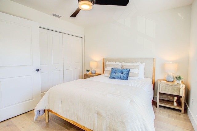 bedroom with hardwood / wood-style floors, ceiling fan, and a closet