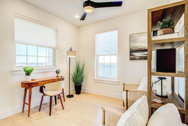 office area featuring a water view, ceiling fan, and light hardwood / wood-style floors