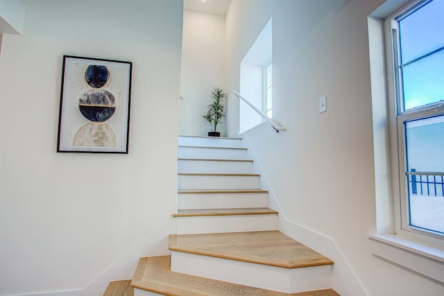 stairs with a healthy amount of sunlight and wood-type flooring