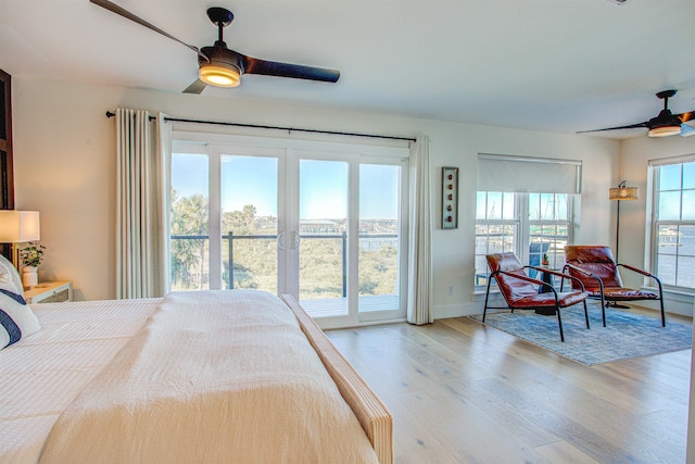 bedroom featuring multiple windows, access to exterior, and light hardwood / wood-style floors