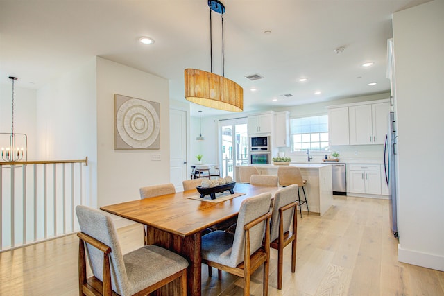 dining area featuring a notable chandelier and light wood-type flooring