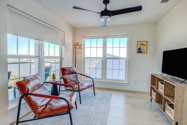 living area with ceiling fan and light wood-type flooring