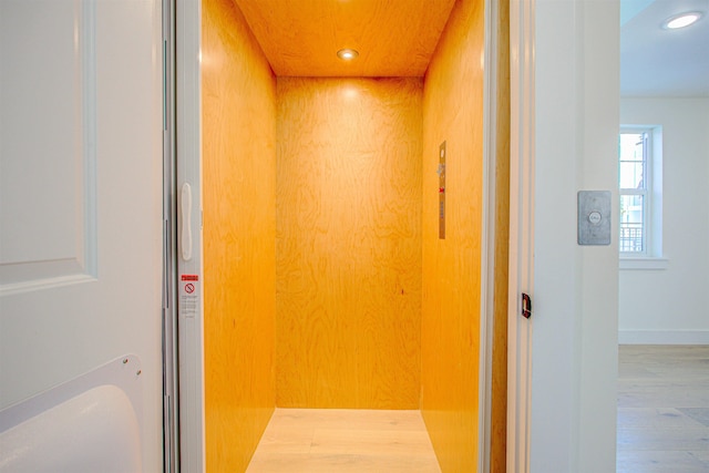 details featuring wood-type flooring and elevator