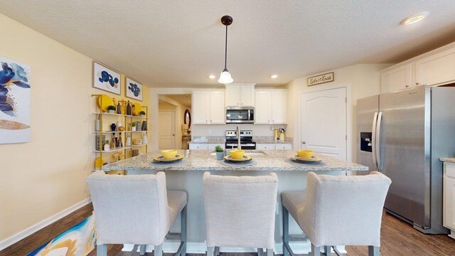 kitchen with pendant lighting, white cabinetry, sink, and appliances with stainless steel finishes