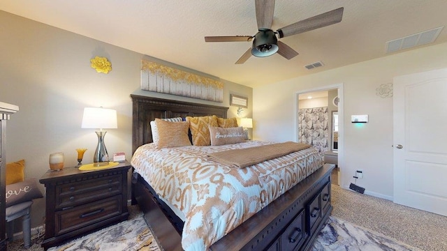 bedroom featuring light carpet, ensuite bath, and ceiling fan