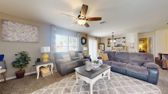 living room featuring carpet flooring and ceiling fan with notable chandelier