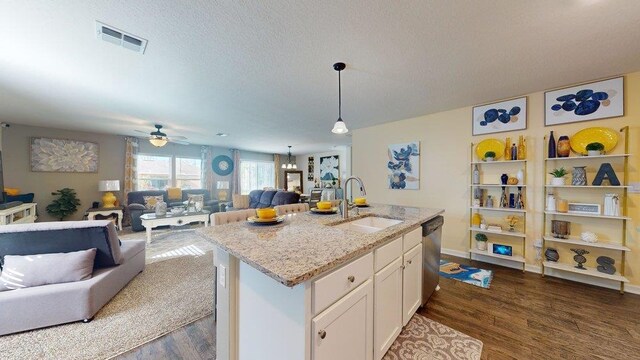 kitchen featuring pendant lighting, ceiling fan with notable chandelier, white cabinets, and light stone counters