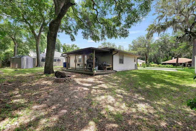 424 Orchis Rd, Saint Augustine, FL 32086 - back of property with a storage unit, a fire pit, and a lawn