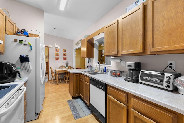 424 Orchis Rd, Saint Augustine, FL 32086 - kitchen with white appliances, light wood-type flooring, light countertops, brown cabinetry, and vaulted ceiling