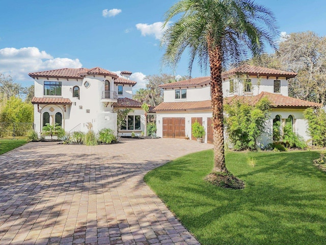 mediterranean / spanish-style home with a front yard and a garage