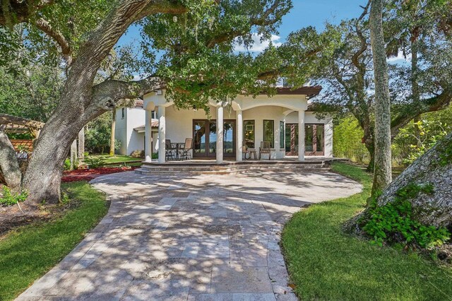 mediterranean / spanish-style home with covered porch and french doors