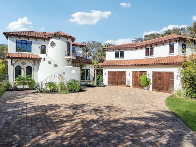 mediterranean / spanish house with a balcony and a garage