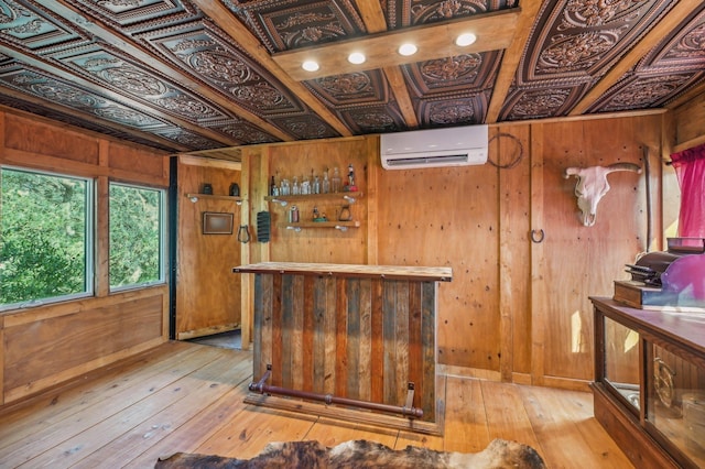 bar with a wall unit AC, wooden walls, light hardwood / wood-style flooring, and coffered ceiling