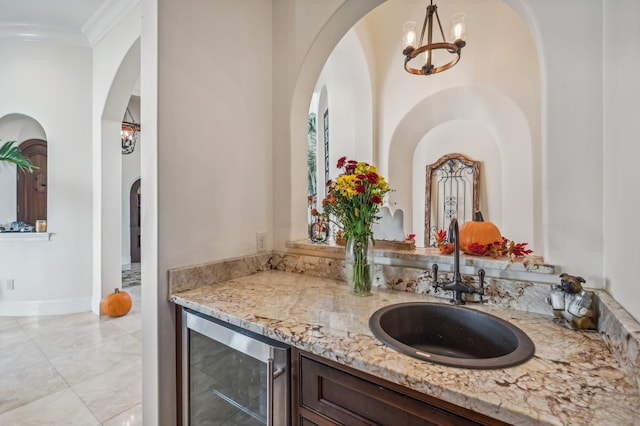 bathroom with crown molding, vanity, beverage cooler, and an inviting chandelier