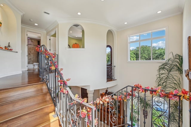 staircase with hardwood / wood-style flooring and crown molding