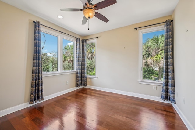 spare room featuring dark hardwood / wood-style flooring and ceiling fan