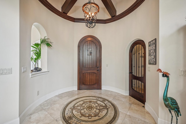 1332 Ponte Vedra Blvd, Ponte Vedra Beach, FL 32082 - tiled entrance foyer featuring a chandelier, arched walkways, baseboards, inlaid floor details, and beamed ceiling