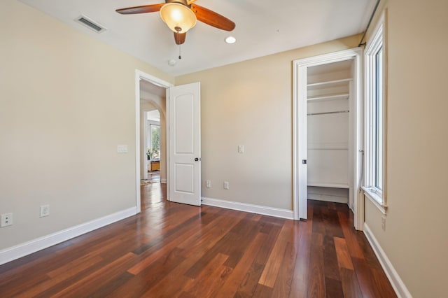 unfurnished bedroom featuring ceiling fan, dark hardwood / wood-style flooring, and a closet