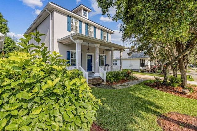 520 Weeping Willow Ln, Saint Augustine, FL 32080 - view of front of home with a porch, stucco siding, and a front lawn