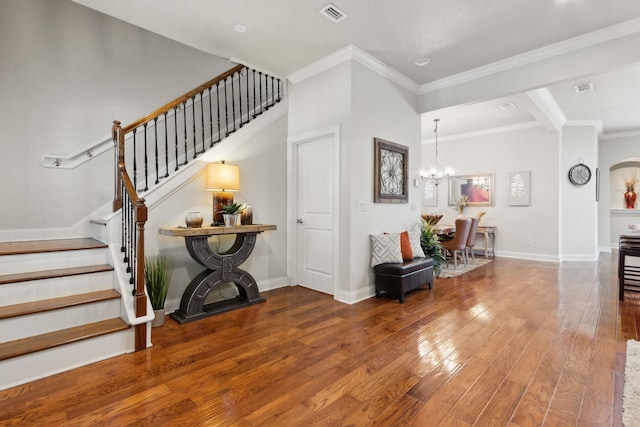 520 Weeping Willow Ln, Saint Augustine, FL 32080 - entrance foyer with wood finished floors, a chandelier, ornamental molding, stairs, and arched walkways