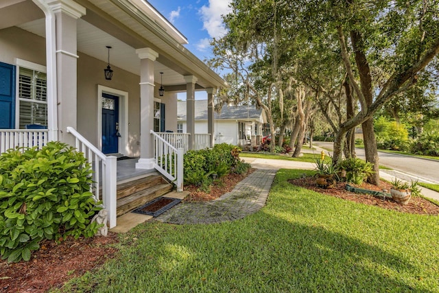 520 Weeping Willow Ln, Saint Augustine, FL 32080 - property entrance featuring covered porch, a lawn, and stucco siding