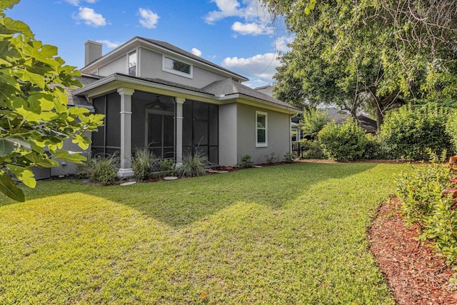 520 Weeping Willow Ln, Saint Augustine, FL 32080 - rear view of property featuring stucco siding, a sunroom, a yard, a chimney, and a ceiling fan