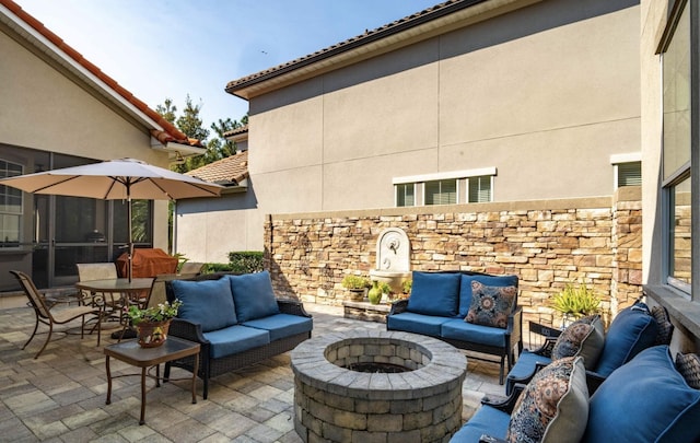 view of patio / terrace with an outdoor living space with a fire pit