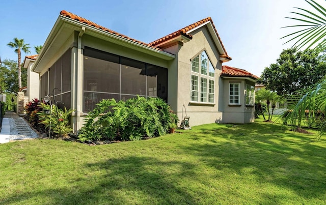 view of property exterior with a sunroom and a yard