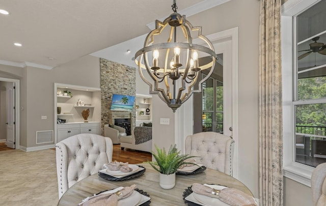 tiled dining space featuring built in shelves, a fireplace, ornamental molding, and a notable chandelier