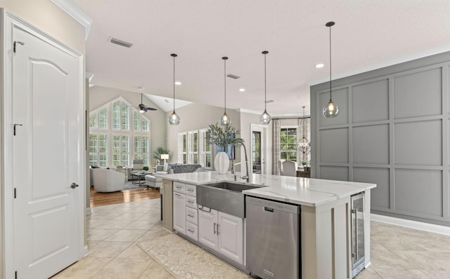 kitchen featuring gray cabinets, plenty of natural light, an island with sink, and stainless steel dishwasher